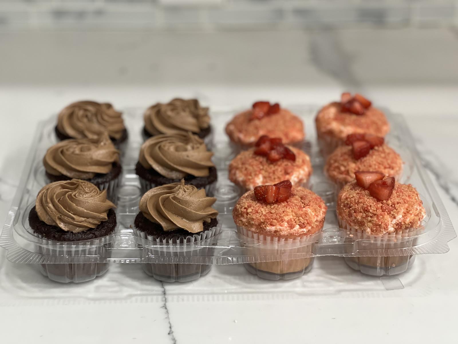 Tray of chocolate mocha cupcakes and strawberry crunch cupcakes topped with fresh strawberries