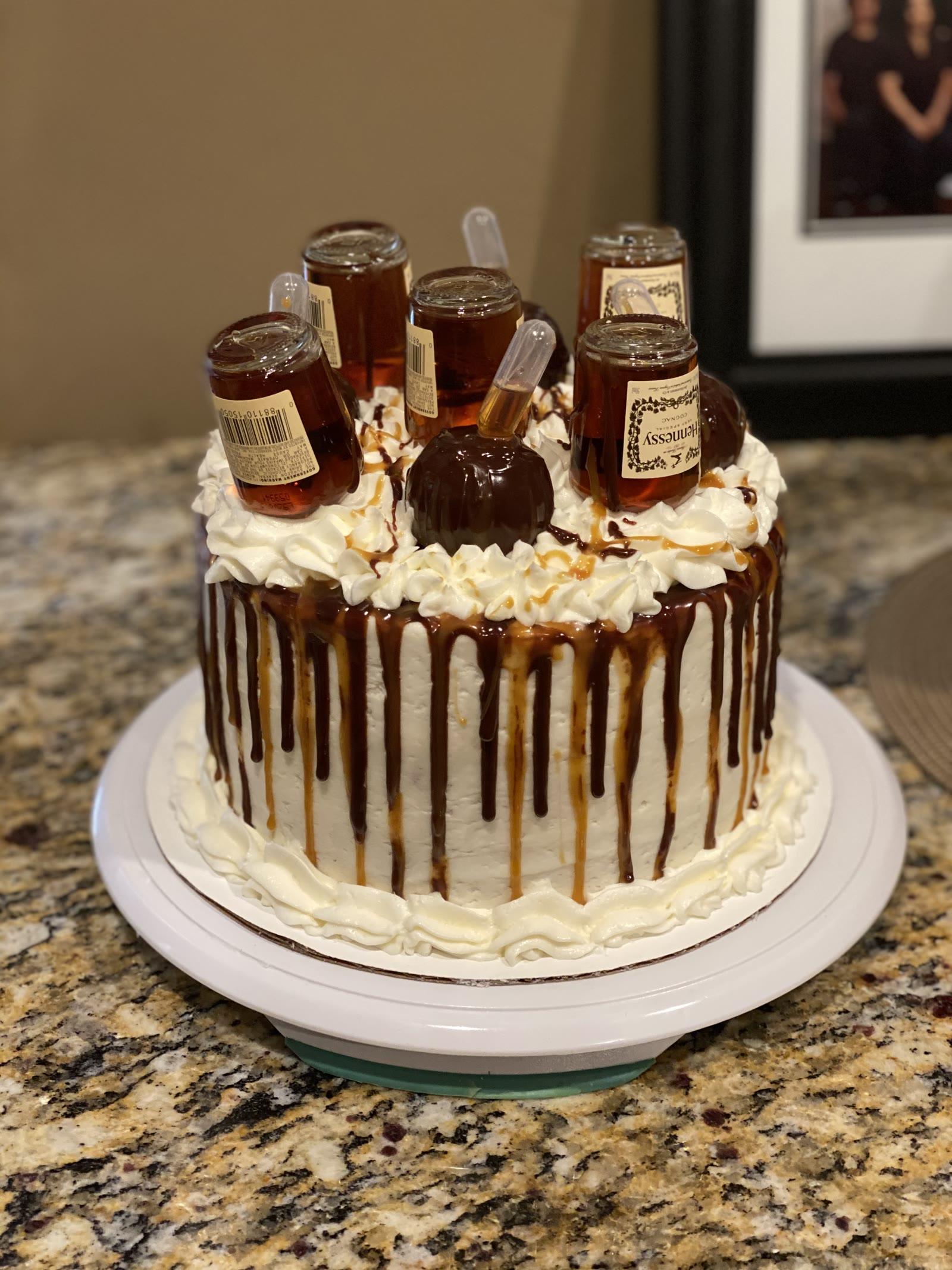 Caramel drip celebration cake for grown-ups topped with mini bottles and whipped swirls