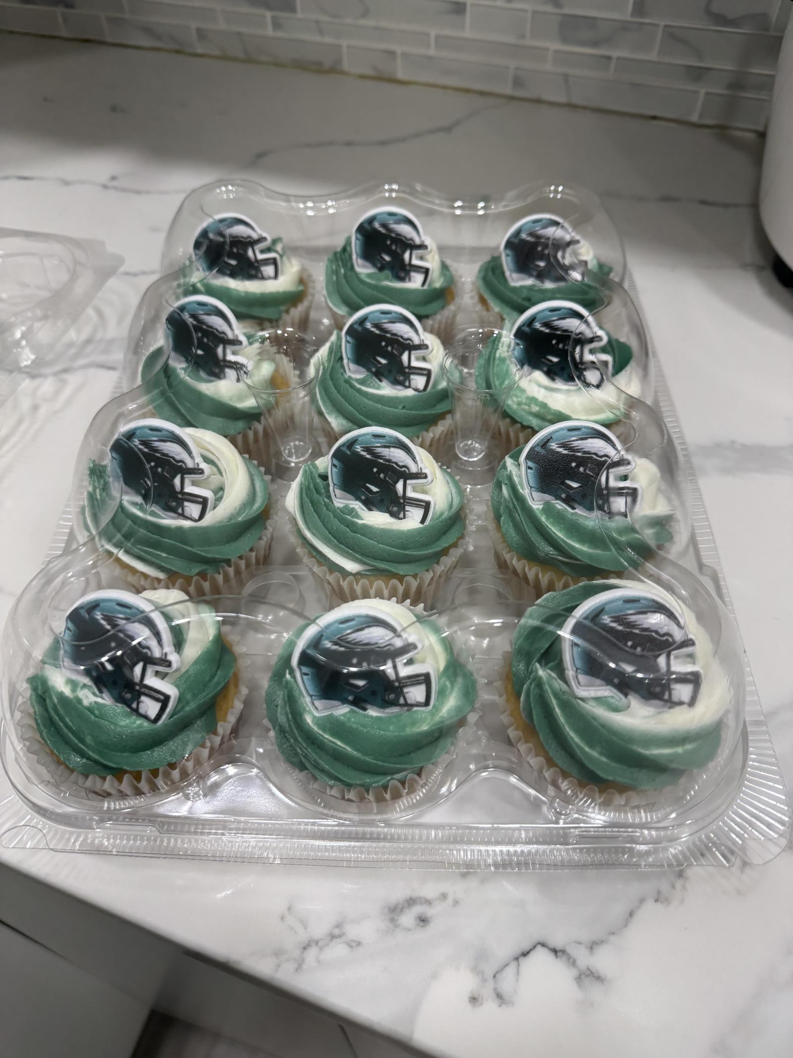Game day football cupcakes with green and white swirled frosting and Eagles helmet toppers