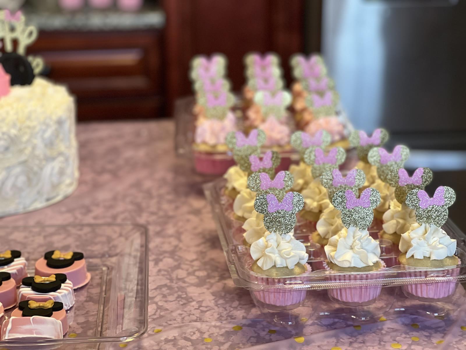 Party cupcakes with tall frosting swirls and glittery Minnie Mouse toppers