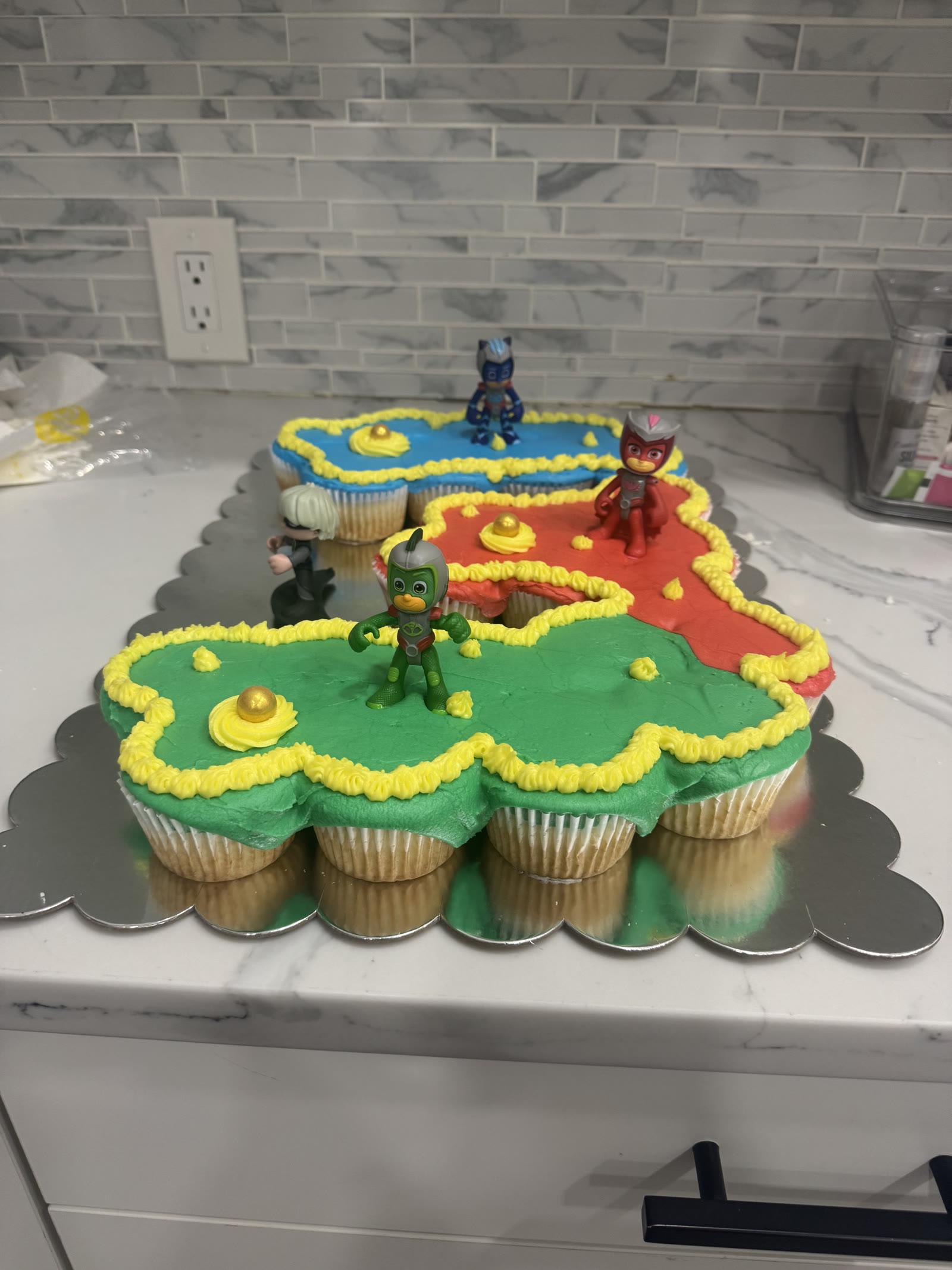 PJ Masks pull-apart cupcake cake with green, red, and blue frosting and character toppers